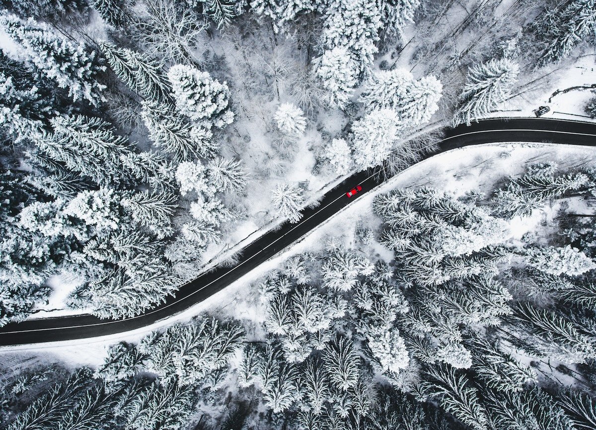 Car on road in winter trough a forest covered with snow Car on road in winter trough a forest covered with snow