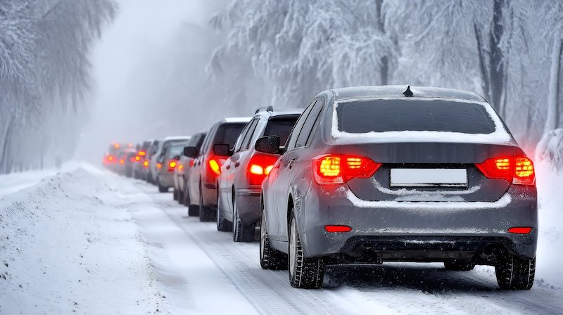 Traffic jam with vehicles on a snow covered road during heavy snowfall
