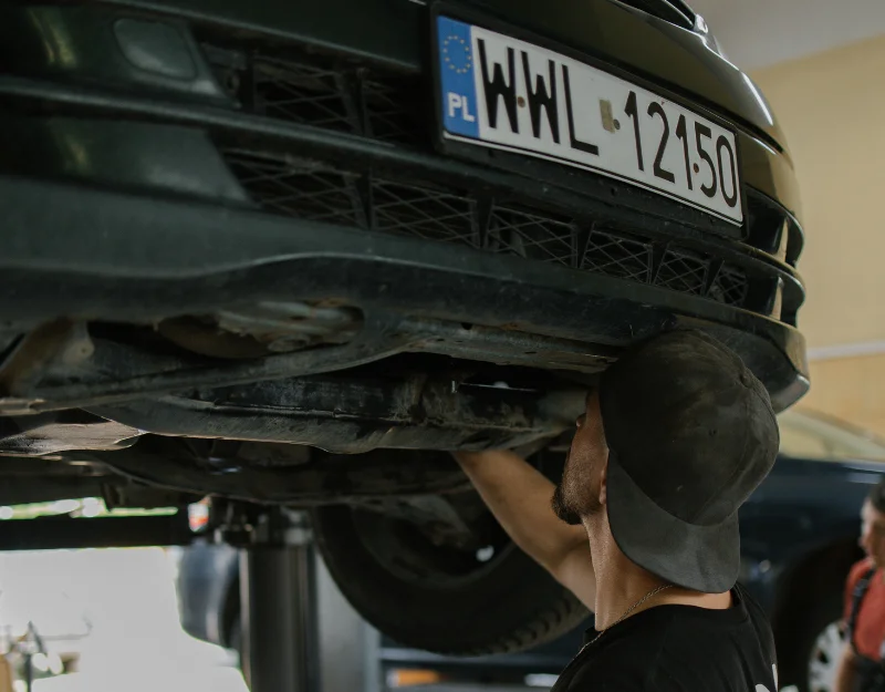 Mechanic inspecting car underside