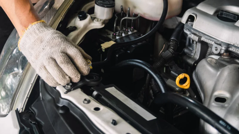 Person working on car engine outdoors