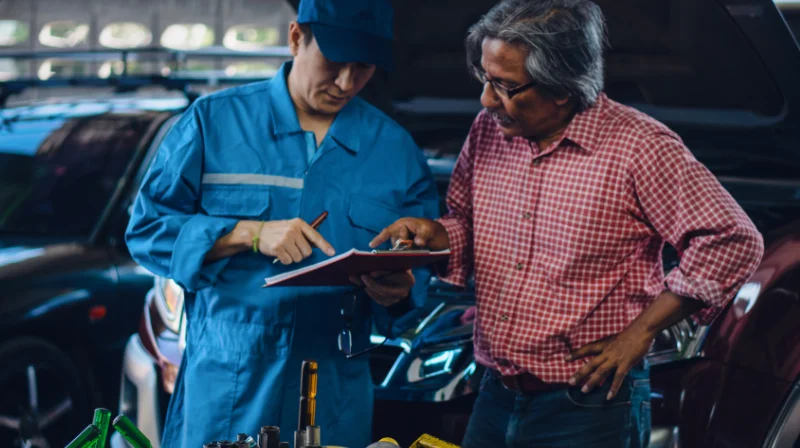 mechanic talking to customer in garage